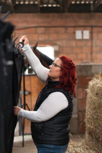 Pferdefotografin beim Aufbau der schwarzen Wand für Fotoshooting mit Pferd in Northeim