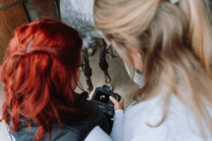 PFerdefotograf blickt mit Kundin auf die Kamera bei Fotoshooting mit Pferd in Northeim