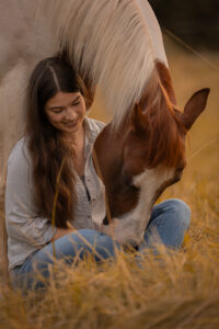 Mensch und Pferd kuscheln auf der Wiese bei Fotoshooting mit Pferd mit Isiful Pictures