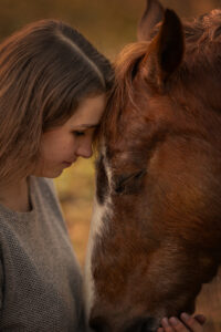 Mensch und Pferd kuschelnd im Wald bei Fotoshooting mit Pferd mit Isiful Pictures Northeim